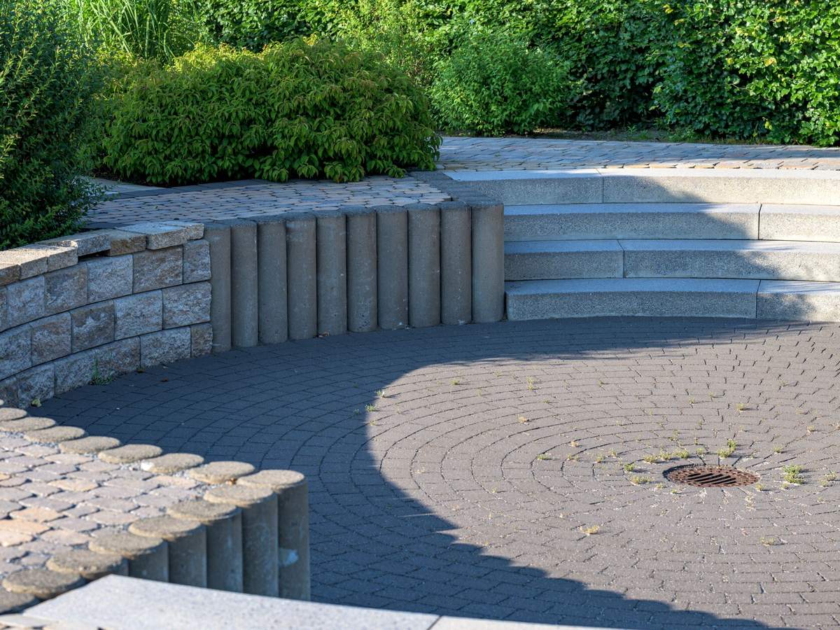 Licensed stock photograph: a circular paved patio with block wall and stone steps.